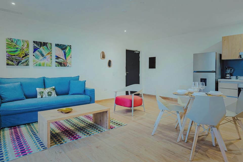 Bright, open-concept living area with comfortable seating, a dining space, and a fully equipped kitchen.