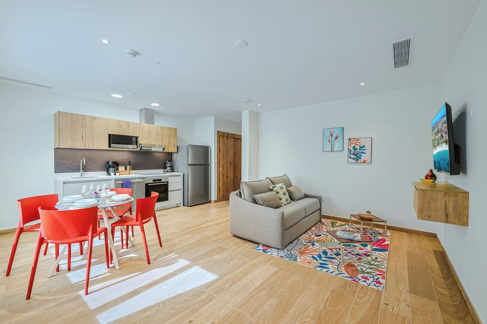 Open, airy living space where you can relax on the plush sofa, share meals at your dining table, and prepare light bites in your well equipped kitchen —all brightened by natural light and thoughtful pops of color.