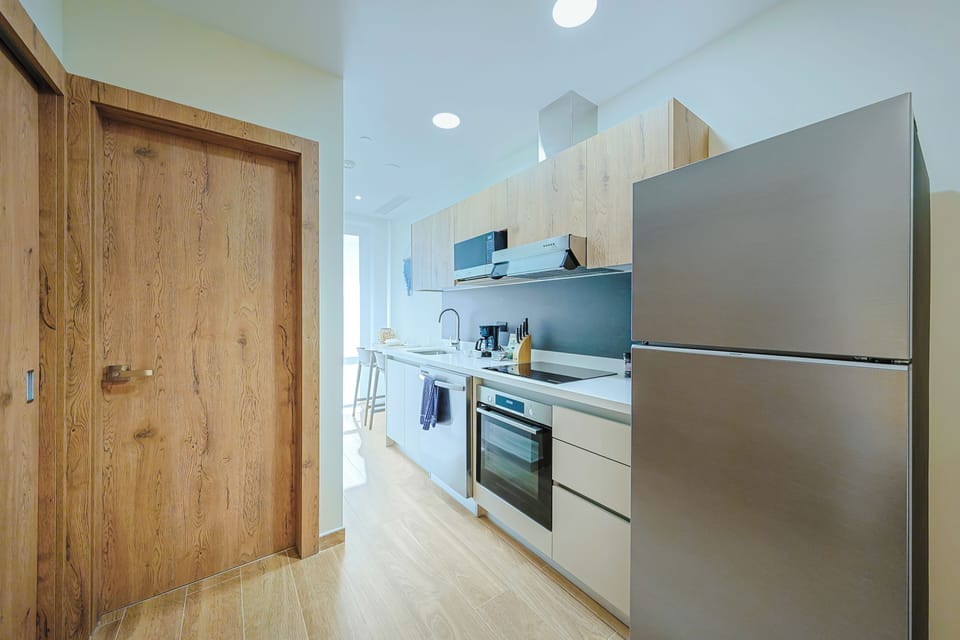 Your sleek modern kitchen offers everything you need to prepare fresh meals, with stainless appliances, ample counter space, and natural light streaming through the open layout.