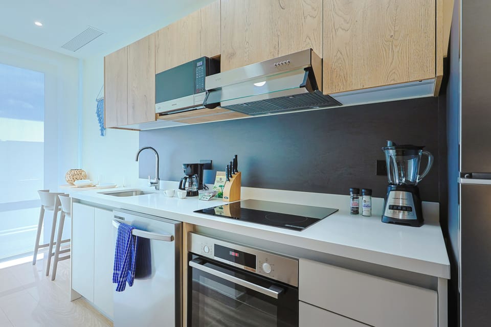 Picture yourself whipping up breakfast in this sleek, modern kitchen, fully equipped with quality appliances, gleaming countertops, and all the essentials for your culinary adventures.