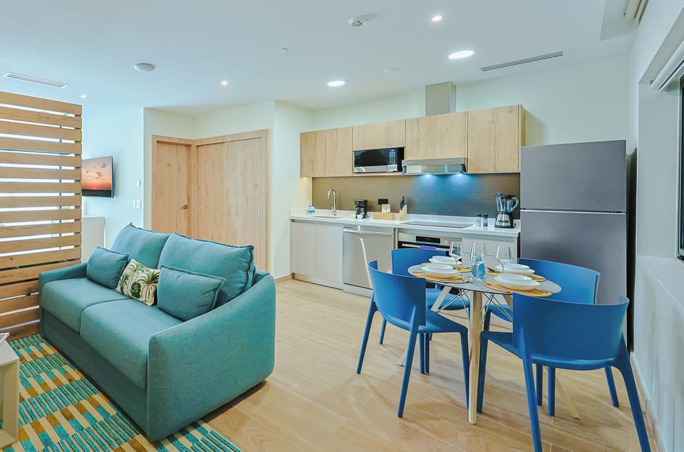 Step into your modern, open-concept retreat, where a welcoming living space flows into a fully equipped kitchen. Your vacation mornings begin at the stylish dining table, surrounded by soothing coastal colors and natural light.