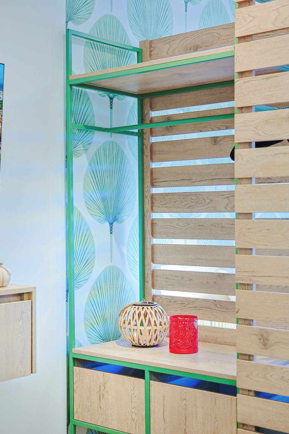 This bright sleeping nook features a cheerful green frame and tropical wallpaper, making your stay feel like a relaxing escape.