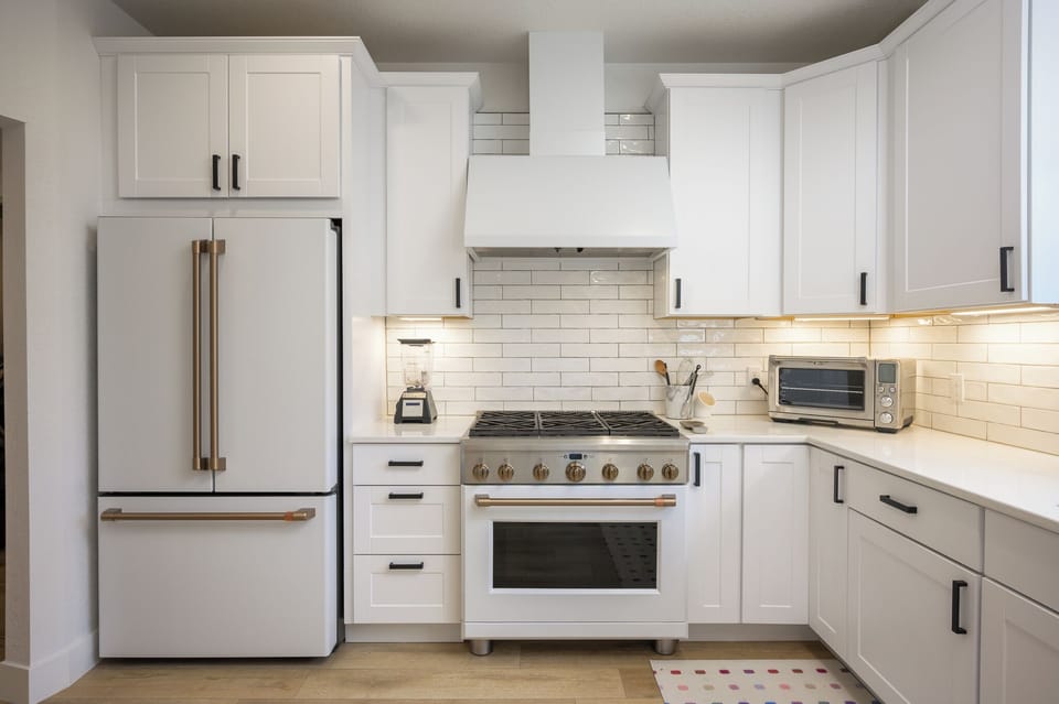 Your modern kitchen features sleek white cabinetry, quality appliances, and warm under-cabinet lighting—perfect for preparing memorable meals during your stay.