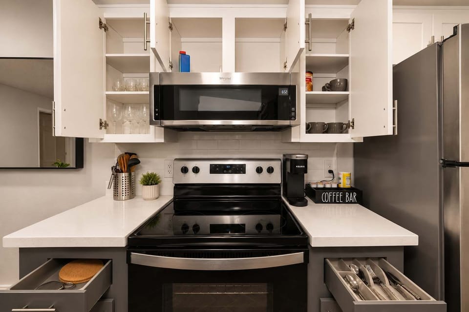 Functional kitchen with oven, stove, fridge and basic cooking ware