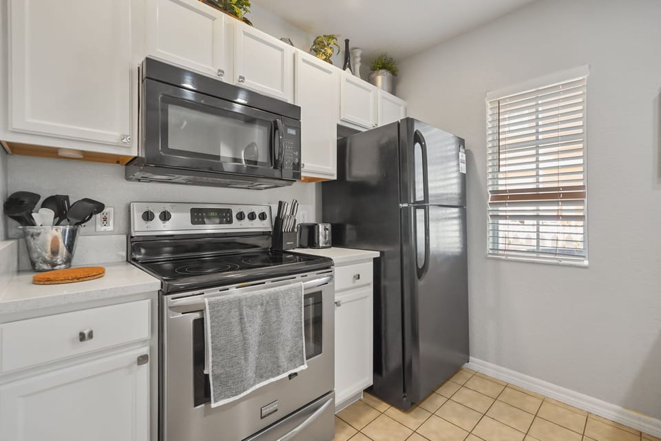 Kitchen area with microwave, stove, fridge, & all you will need for your needs.