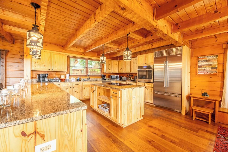 Step into your fully equipped chef's kitchen, where soaring wood beam ceilings and gleaming granite countertops set the stage for memorable meals together.