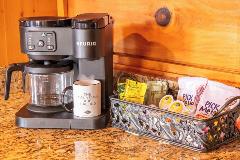 Start your mornings right with a thoughtfully stocked coffee station. Brew your perfect cup with the Keurig, enjoy a variety of teas, and sweeten to taste with all the essentials within easy reach.