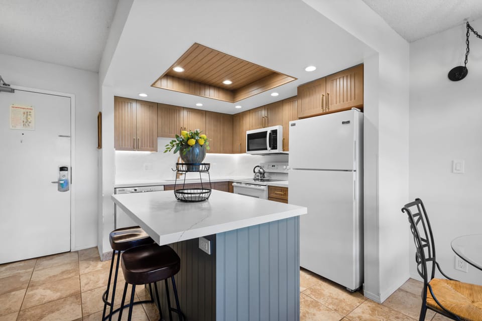 Your stylish kitchen awaits, with warm wood cabinetry, a bright island for meals or conversation, and modern appliances to make cooking a breeze. Natural light and thoughtful design create a welcoming space to enjoy your stay.