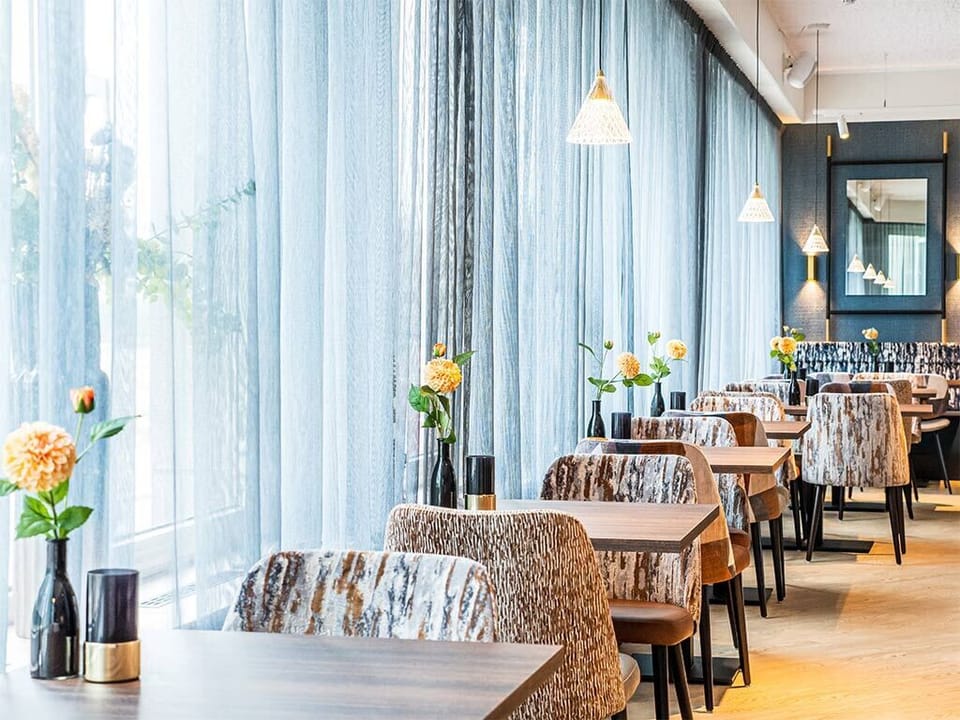 Savor breakfast by sunlit windows in a calm setting.