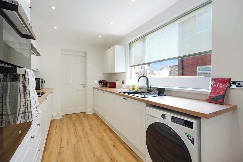 Cook with ease in the well-equipped kitchen, featuring an oven, hob, microwave, fridge/freezer, washing machine, and essential cooking utensils. Perfect for everything from light snacks to home-cooked meals.