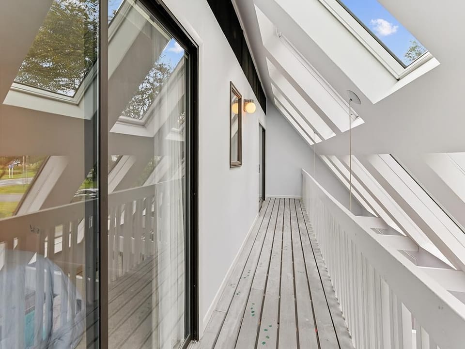 Airy upper-level hallway with skylights and a breezy, open feel