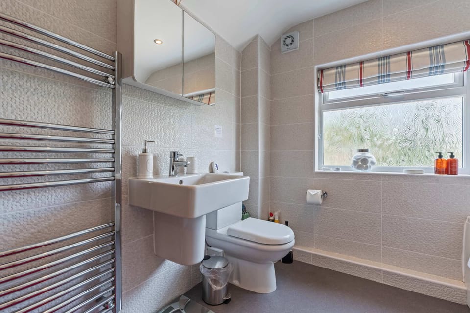 The family bathroom features a full sized bath with an overhead shower, a toilet and a sink basin. Complimentary toiletries consist of the Odyssey Shampoo and Conditioner & cotton wool.