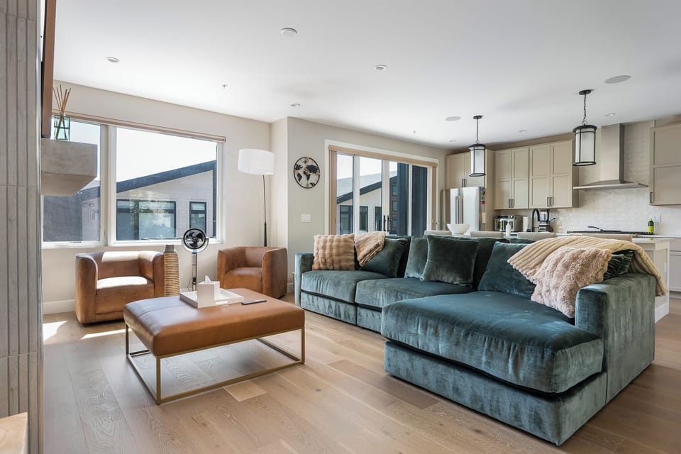Sink into the plush velvet sofa and let natural light fill this open-concept living space. Your fully equipped kitchen awaits just steps away, perfect for preparing meals while staying connected to your group.