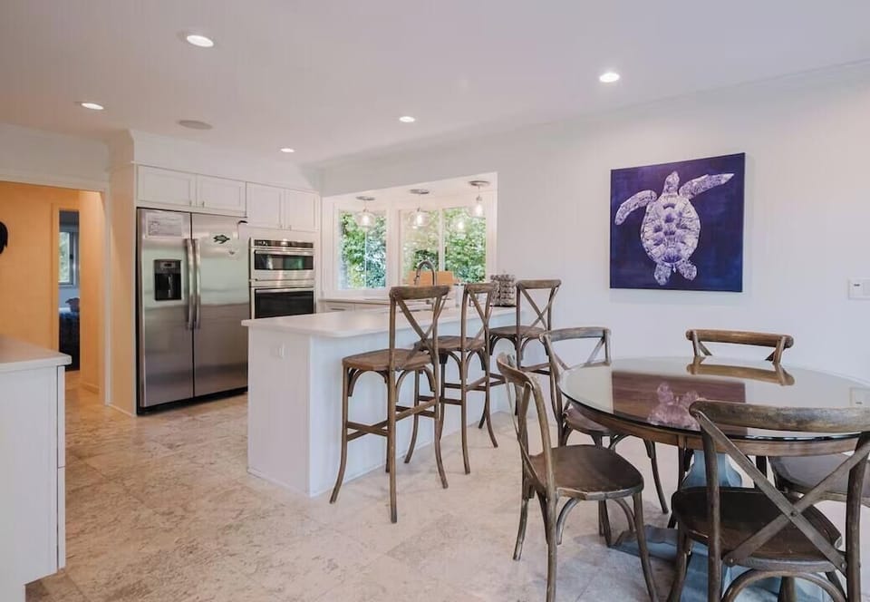 Gather with your crew around the circular dining table or pull up a stool at the breakfast bar, where coastal charm meets modern convenience in this bright, open-concept space.
