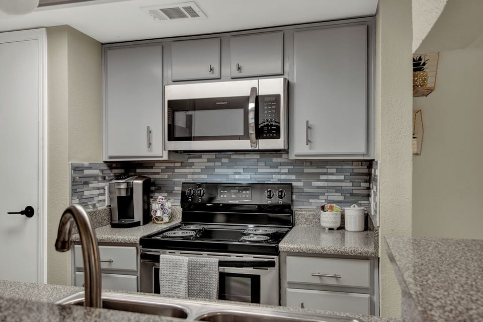 Fully equipped kitchen with granite and modern appliances.