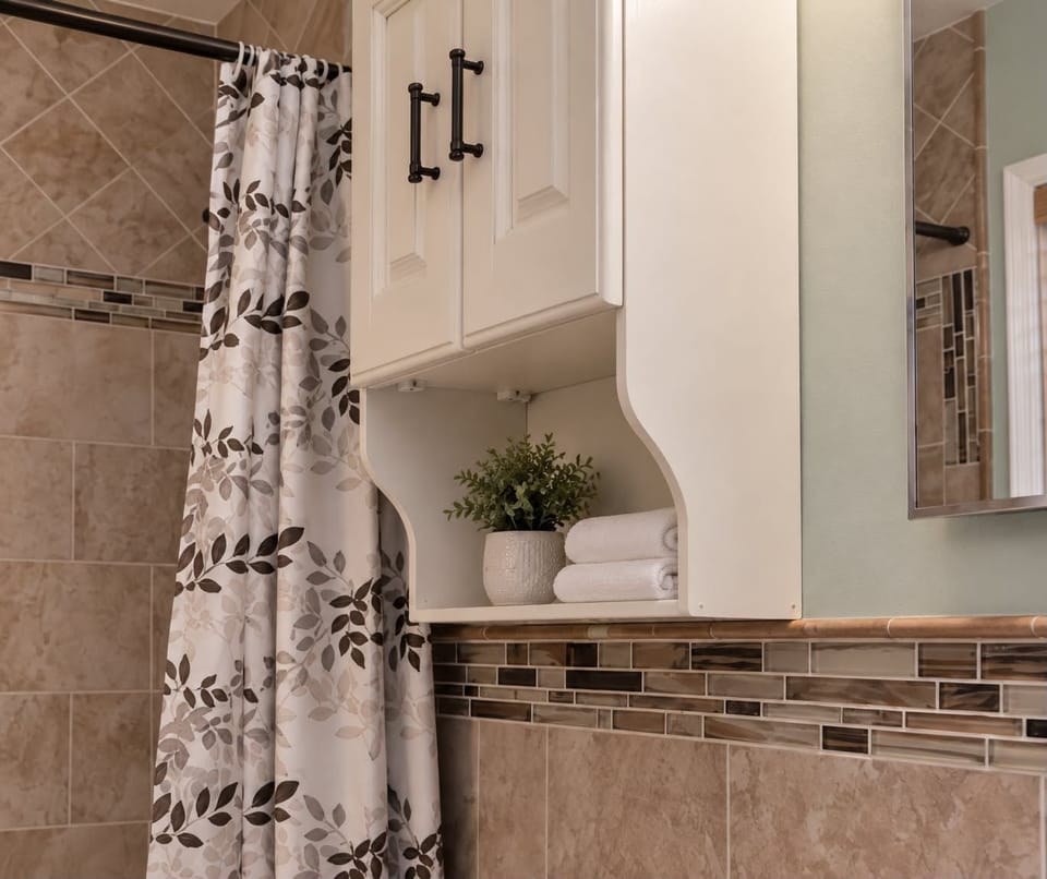 Bright tiled bathroom with stylish accents and convenient storage
