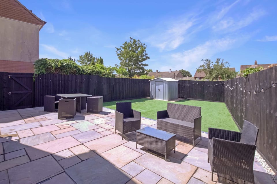 Private, enclosed garden with a spacious patio, outdoor dining set, comfortable seating, and a lawn—perfect for enjoying your morning coffee, al fresco meals, or relaxing in the fresh air.