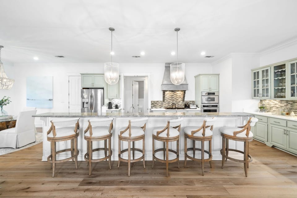 Your gourmet kitchen awaits with marble counters, premium appliances, and seating for six at the stunning island.