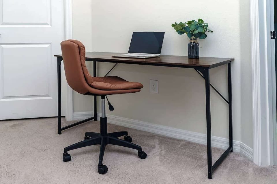 This dedicated workspace features a modern wooden desk and comfortable rolling chair, creating a quiet spot for work or study.