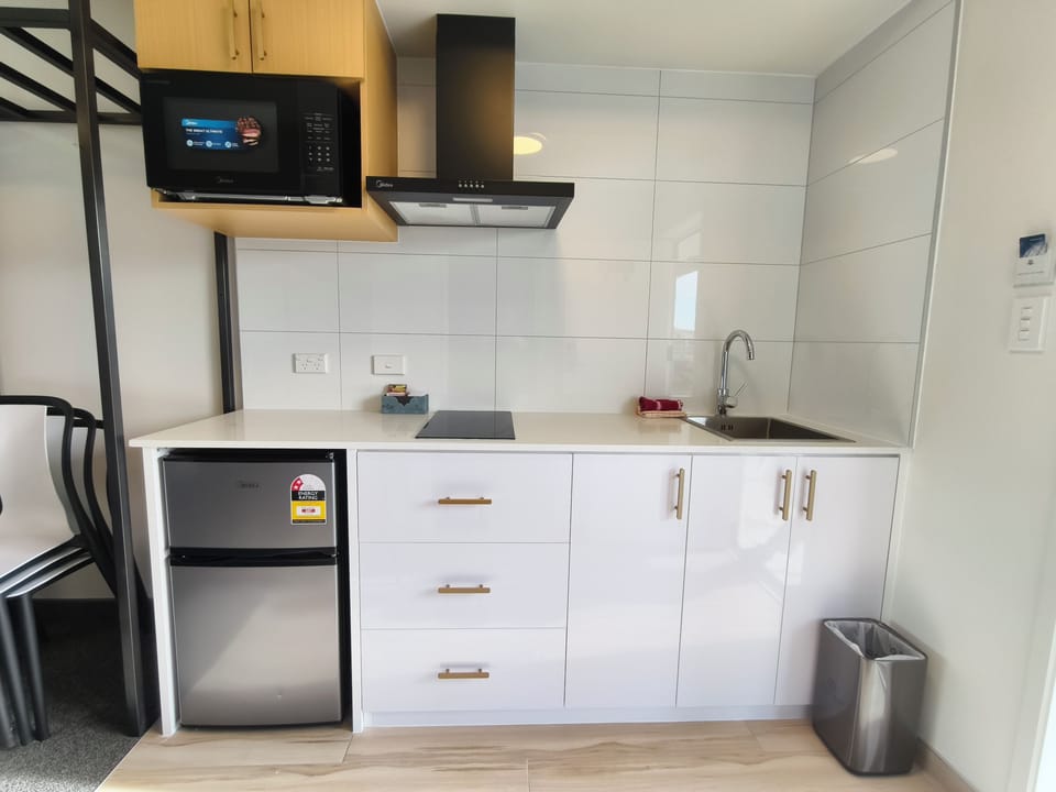 Spacious accessible bathroom with roll-in shower, folding shower seat and grab rails.