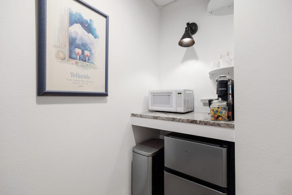 Simple snack station with mini fridge/freezer, microwave and Keurig coffee maker.