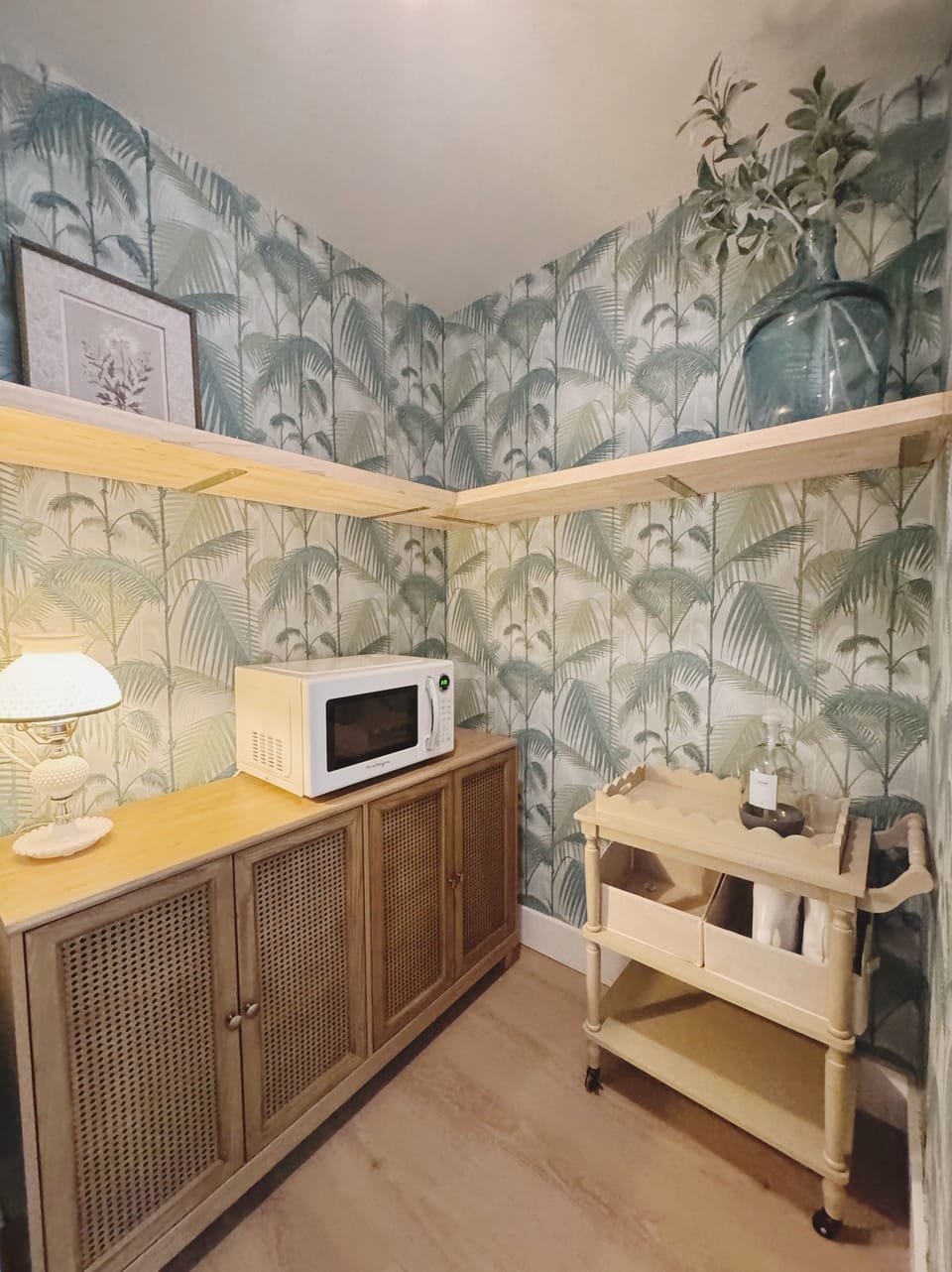 Chic tropical coffee bar nook with microwave, shelving, and stylish cart