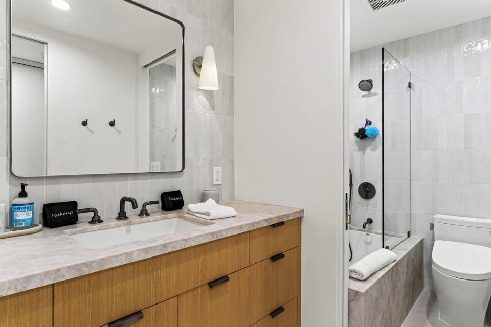 Modern bathroom with shower-tub combo and vanity.
