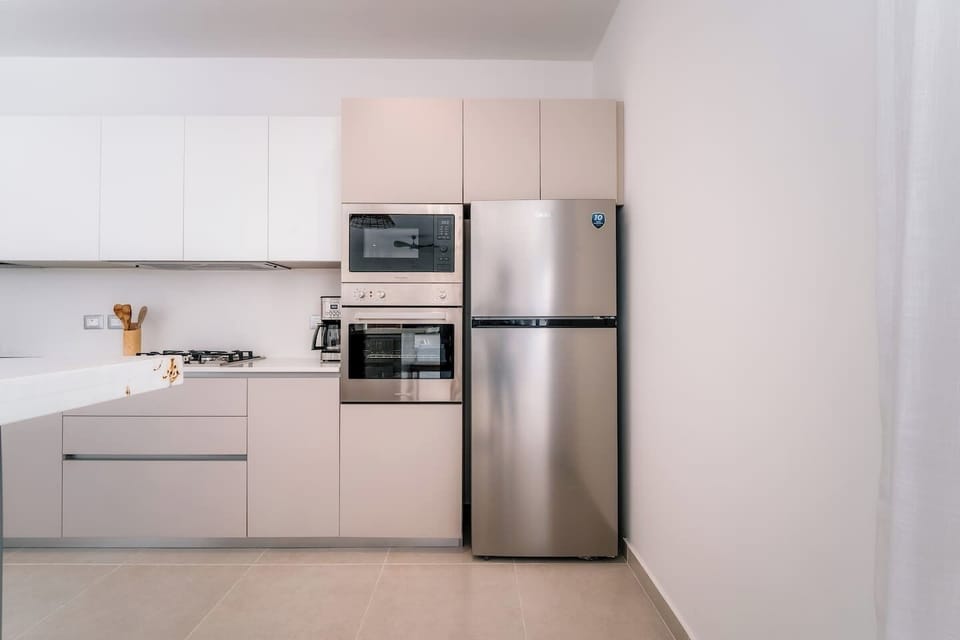 Modern, fully equipped kitchen with plenty of cabinet space, a gas cooktop, oven, microwave, coffee maker, and full-size refrigerator.