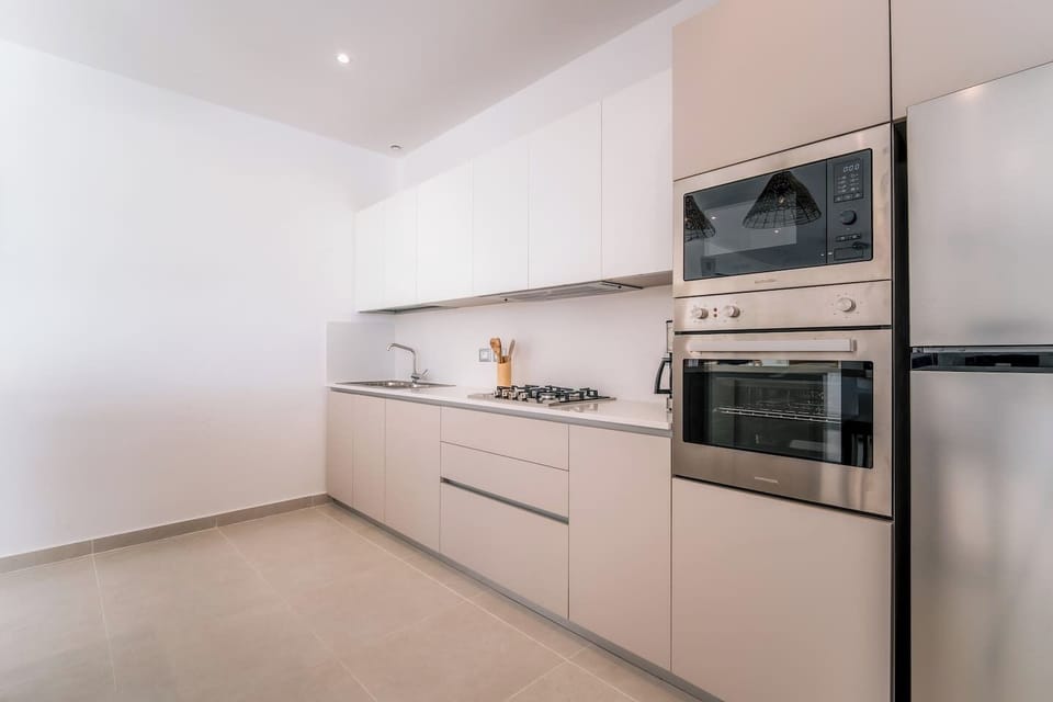 A clean, modern fully equipped kitchen with built-in appliances, ample storage, and plenty of counter space for preparing meals.