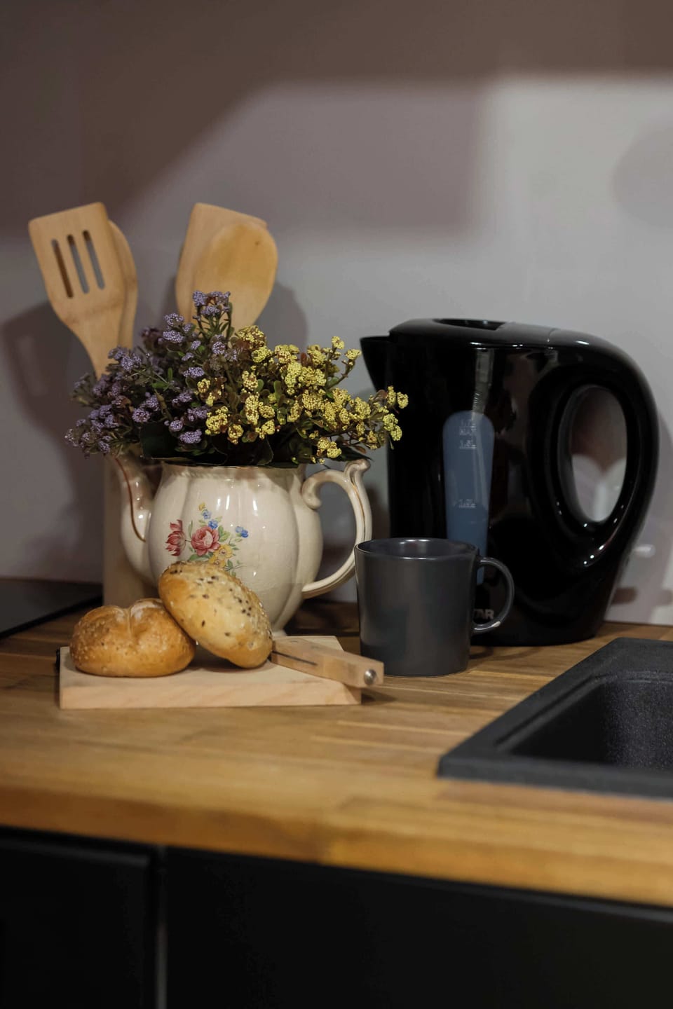 Kitchenette countertop with a kettle, decorative items, and various kitchen accessories.
