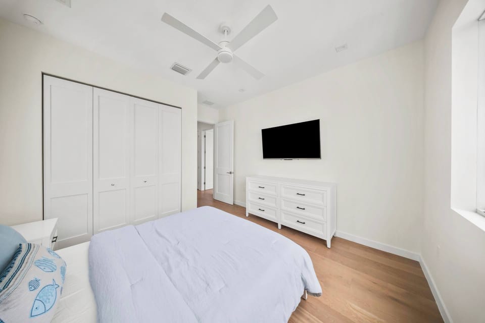 Bedroom with Queen sized bed with brand new furniture and decor with TV and tons of natural light with multiple windows. 