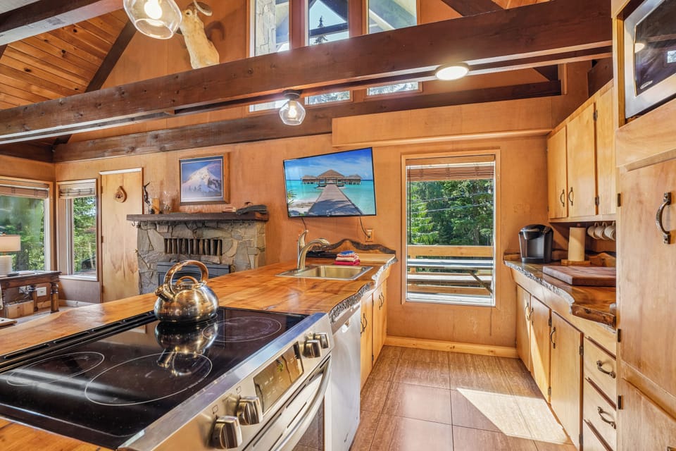 Kitchen: Sunlit space with sleek appliances, unique wood accents, and scenic forest views!