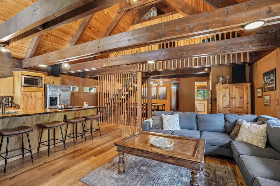 Living Room: Spacious charm with high ceilings, warm wood beams, and inviting seating for gatherings!