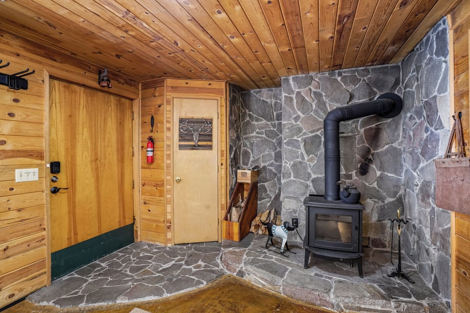 Entryway: Rustic charm welcomes you with stone accents and a cozy wood stove!