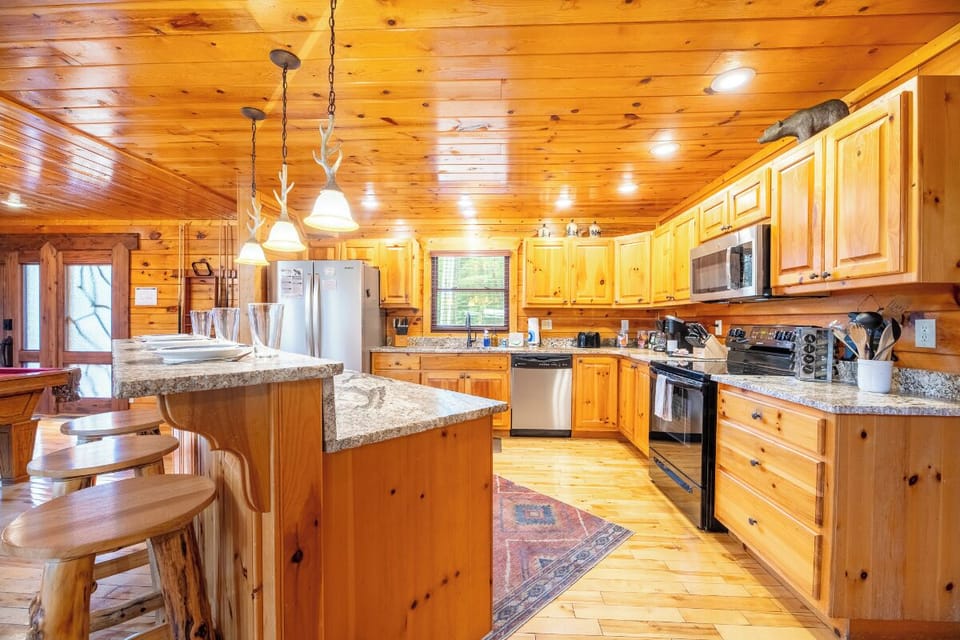 Gather around your fully equipped kitchen with warm wood cabinetry, granite counters, and plenty of space to cook and connect with family.
