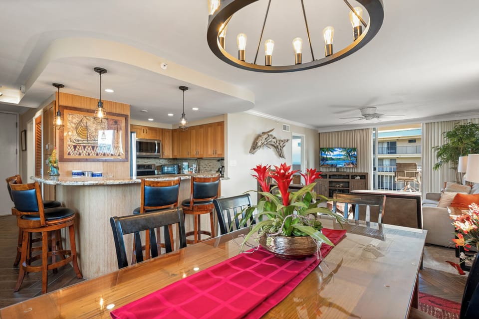 Gather around the beautiful dining table or relax at the kitchen bar in this open-concept space, where warm wood tones and coastal touches create an inviting atmosphere for your vacation meals and conversations.