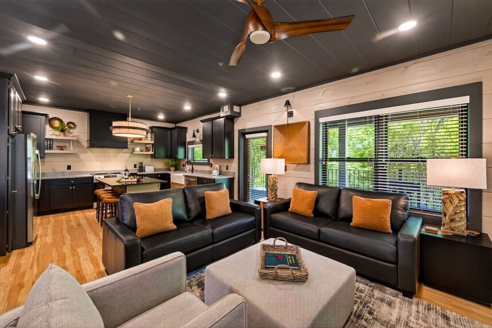 Living room looking toward kitchen- Large rear windows lead to the balcony with rocking chairs overlooking the backyard