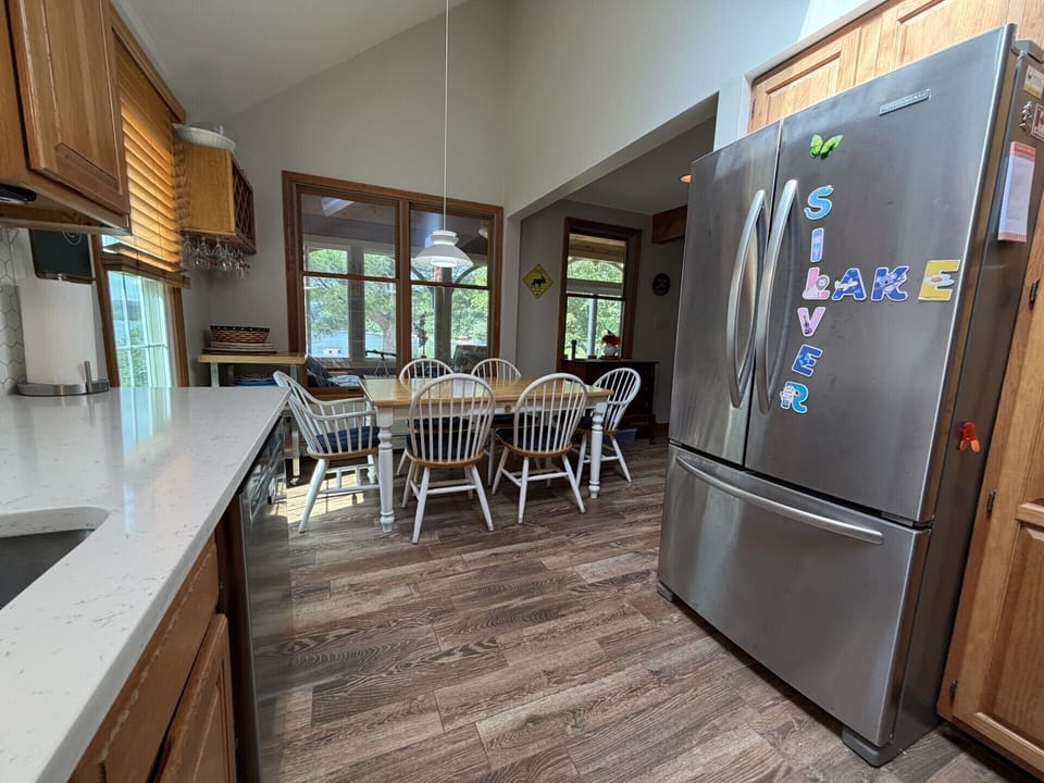 Gather around the dining table in your fully-equipped kitchen, where sunlight streams through large windows and playful fridge magnets add a homey touch. Everything you need to cook and share meals together.