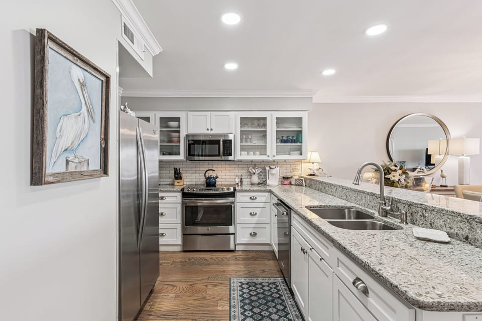 Cook memorable meals in this fully equipped kitchen with granite counters, stainless appliances, and coastal charm throughout your stay.