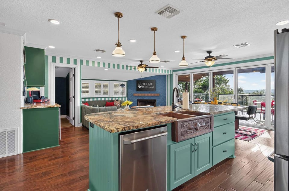 Prepare meals with a view from a spacious kitchen island featuring a farmhouse sink, modern appliances, and a direct line of sight to the living room and outdoor scenery.