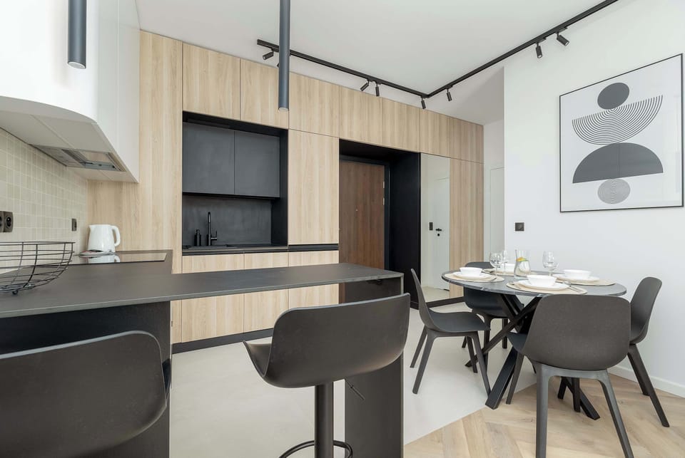 A stylish dining area is connected to the modern kitchenette. The space has contemporary furniture and a bright interior.