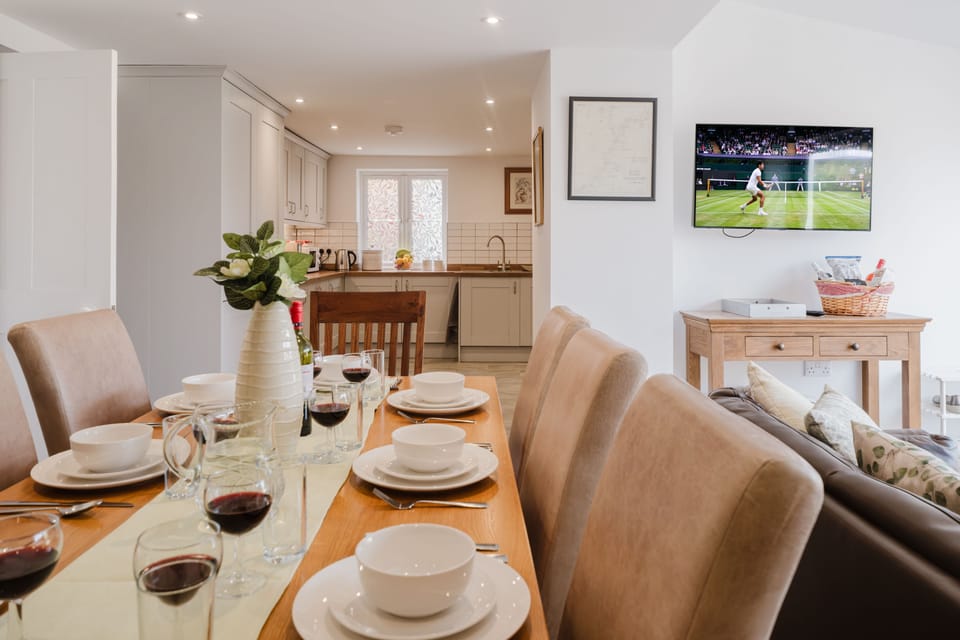 Dining area situated at the rear of the garden room with flagstone floors and a large dining table seating eight guests