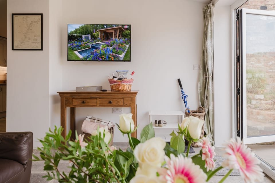 A large, wall-mounted Smart television in the garden room
