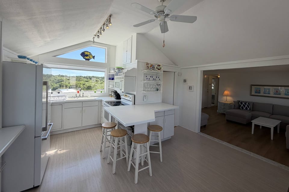 Fully stocked kitchen, stool seating, and living room