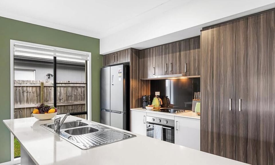 Stone bench tops in kitchen with dishwasher under island bench