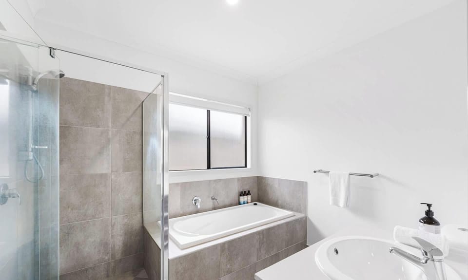 Main bathroom has full length bath and separate shower with optional hand held shower.