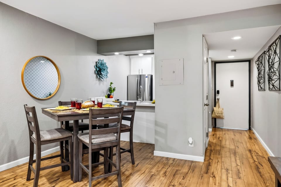 Dining area featuring a round decorative wall mirror and table setting.