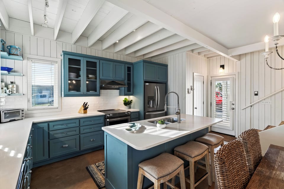 Blue cabinetry, stainless appliances and island prep space.