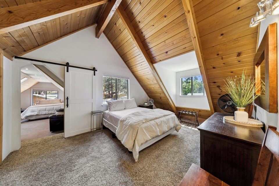 Bonus sleeping area connected to Bedroom 3 where vaulted wood ceilings and natural light create a cozy mountain retreat. Settle into the plush bed and soak in the serene ambiance of this inviting space.