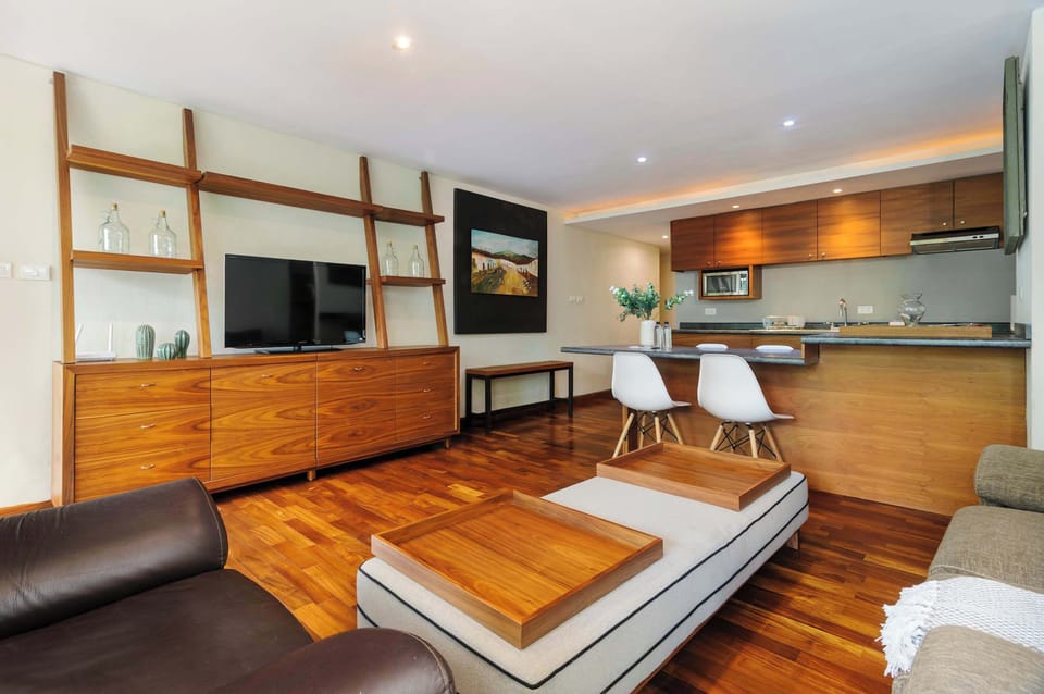 Open-concept living and kitchen area with warm wood details, comfortable seating, and a modern layout.